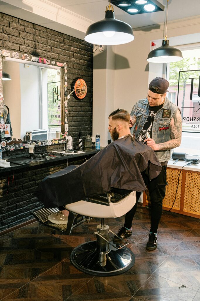 A barber giving a stylish haircut to a client in a trendy urban barbershop.